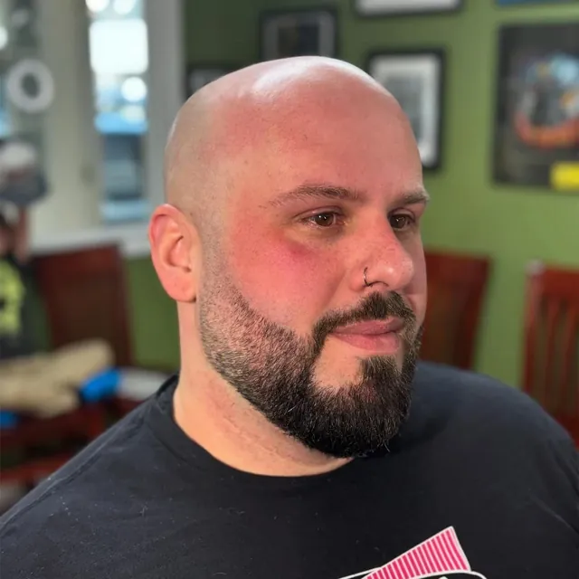 Clean head shave with a shaped beard.